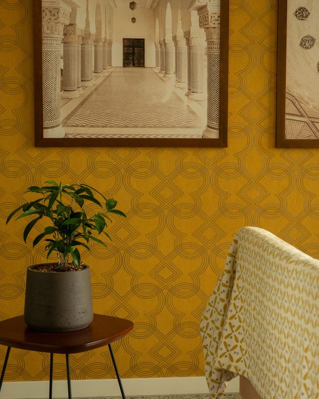 Living corner with a mustard-yellow art-deco geometric wallpaper