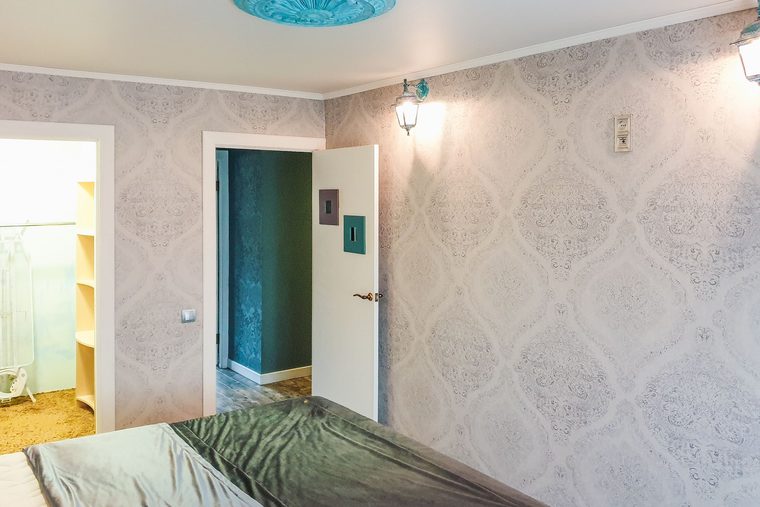 Bedroom with soft grey damask wallpaper and a ceiling medallion