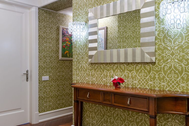 Hallway with olive-green and silver scrollwork damask wallpaper