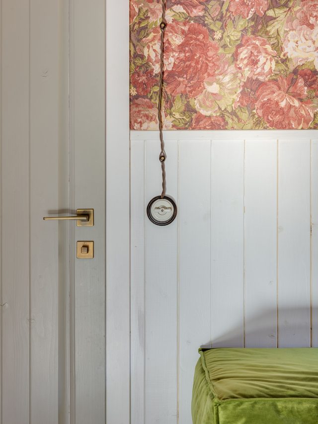 Vintage rose floral wallpaper above white beadboard wainscoting