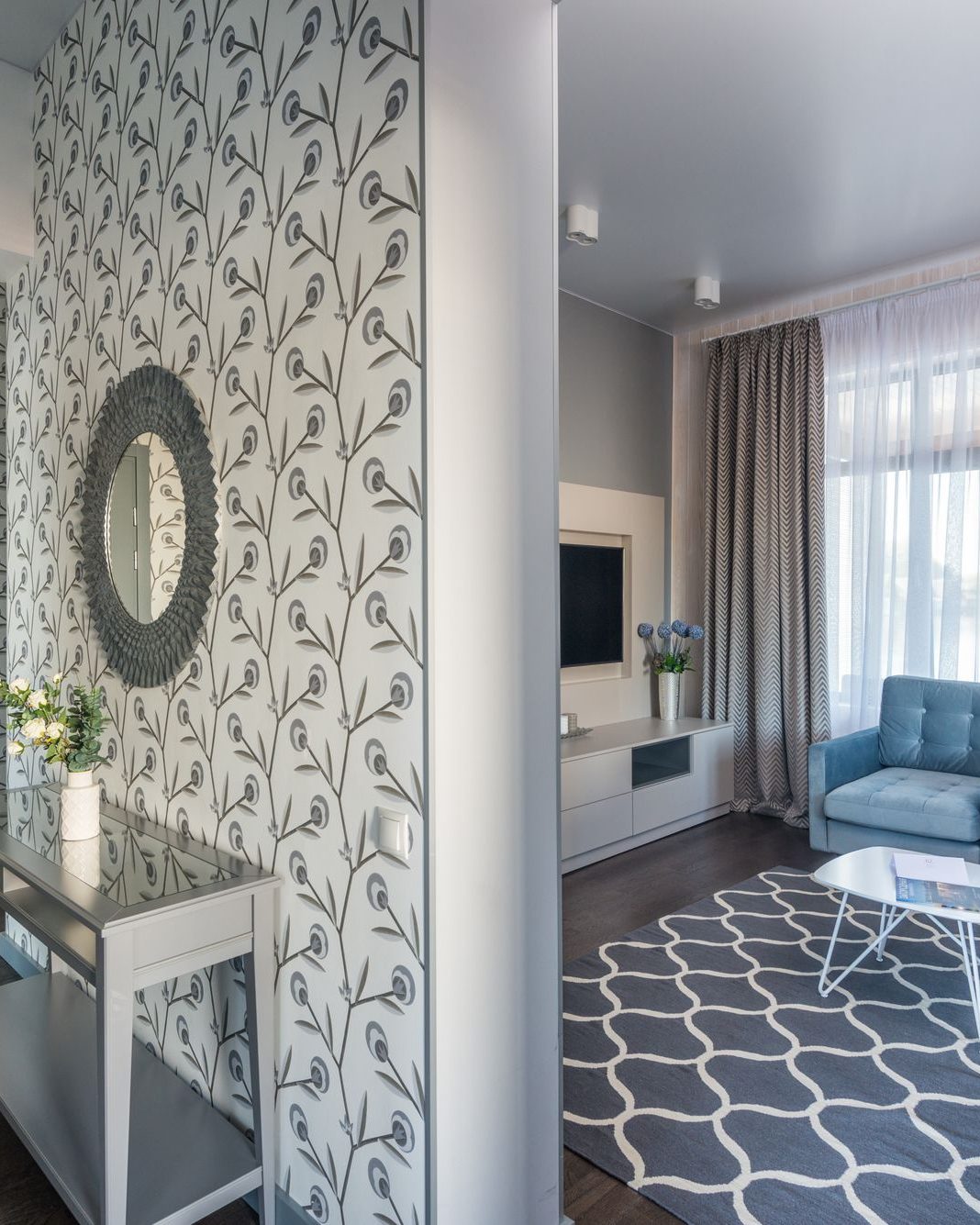 Modern living room with a soft grey botanical feature wall and neutral furnishings